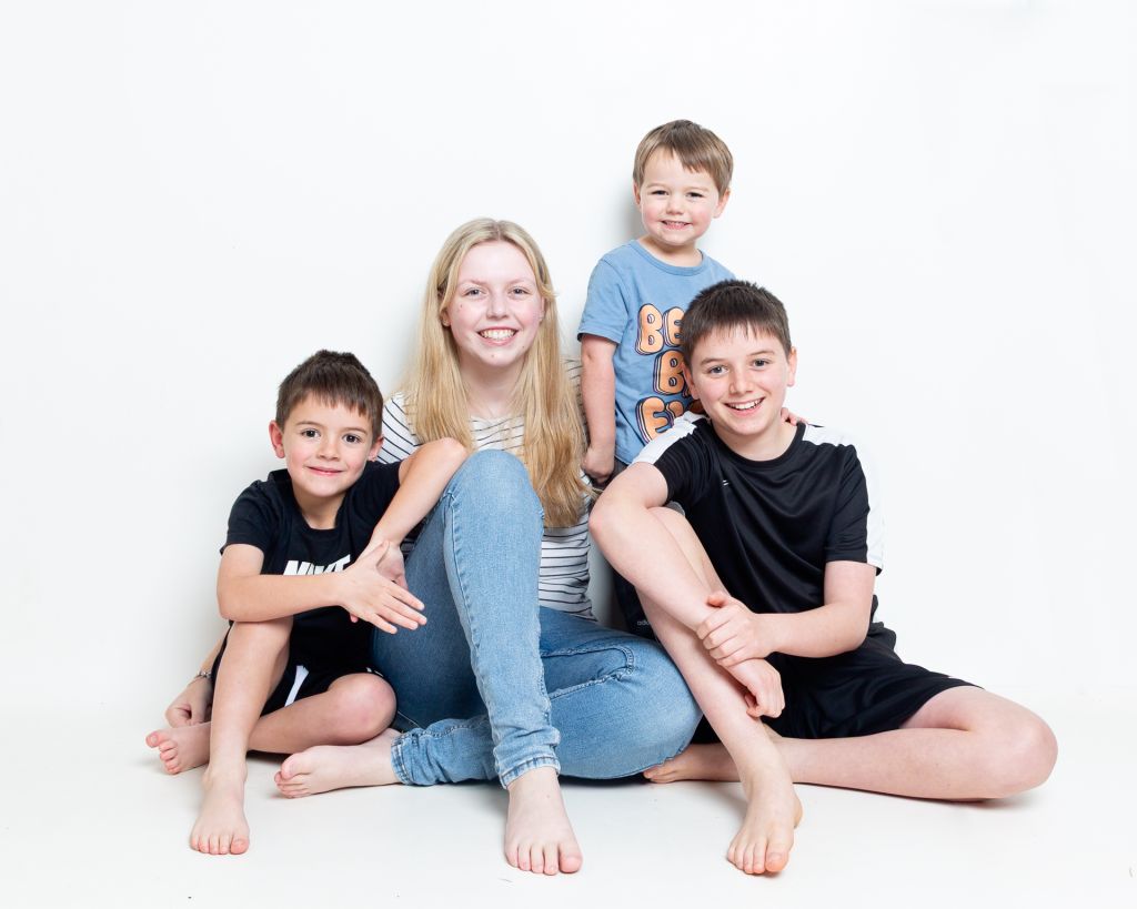 Five Children pose seated for a relaxed family portrait