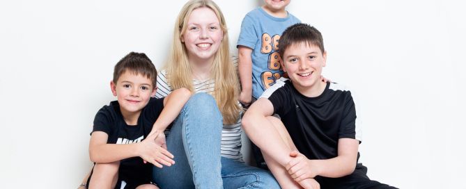 Five Children pose seated for a relaxed family portrait