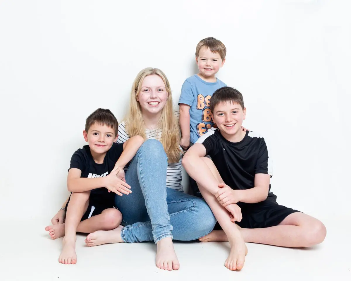 Five Children pose seated for a relaxed family portrait