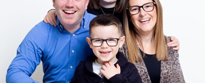 A family of mum, dad and two children pose for a professional photo shoot