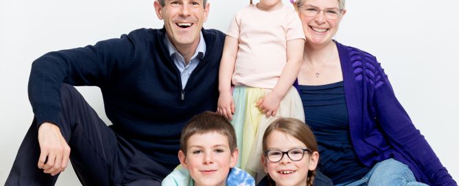 A family of five pose seated for a relaxed family portrait