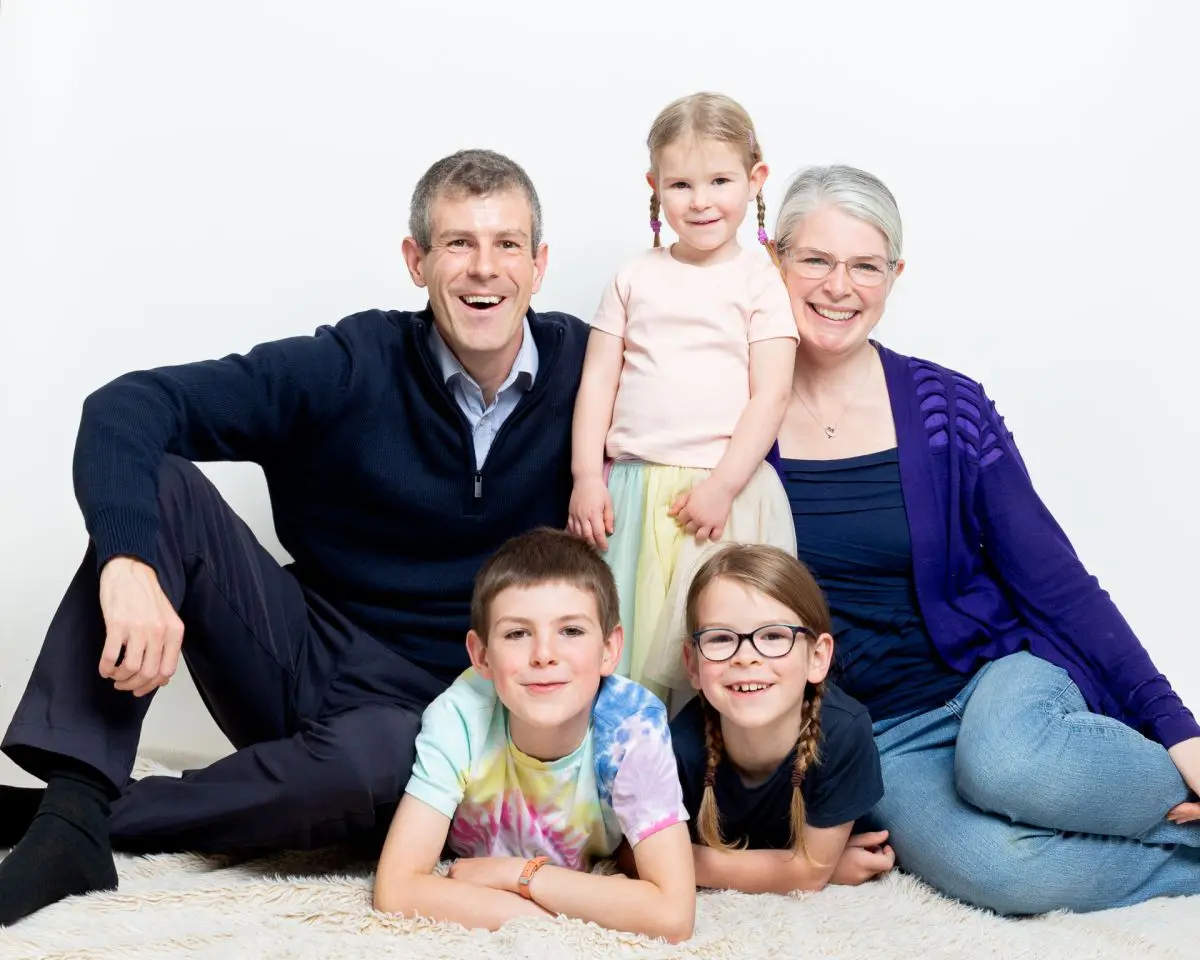 A family of five pose seated for a relaxed family portrait