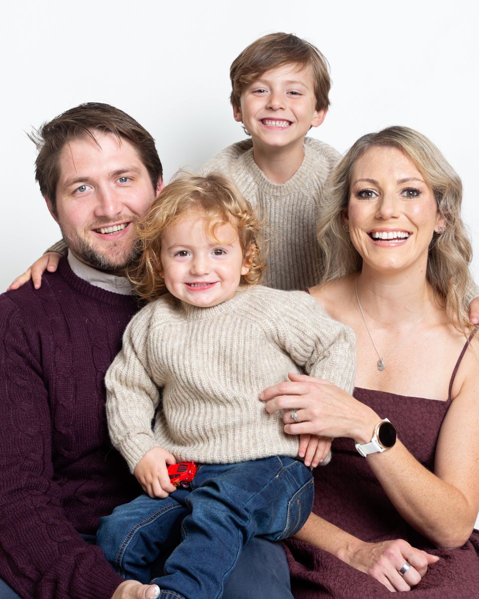 A family with two boys pose for a photograph