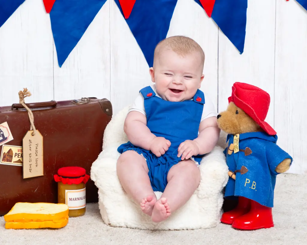 a little boy laughs dresses as Paddington Bear