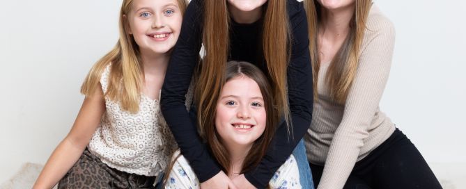 A group of four girls pose for a family photograph