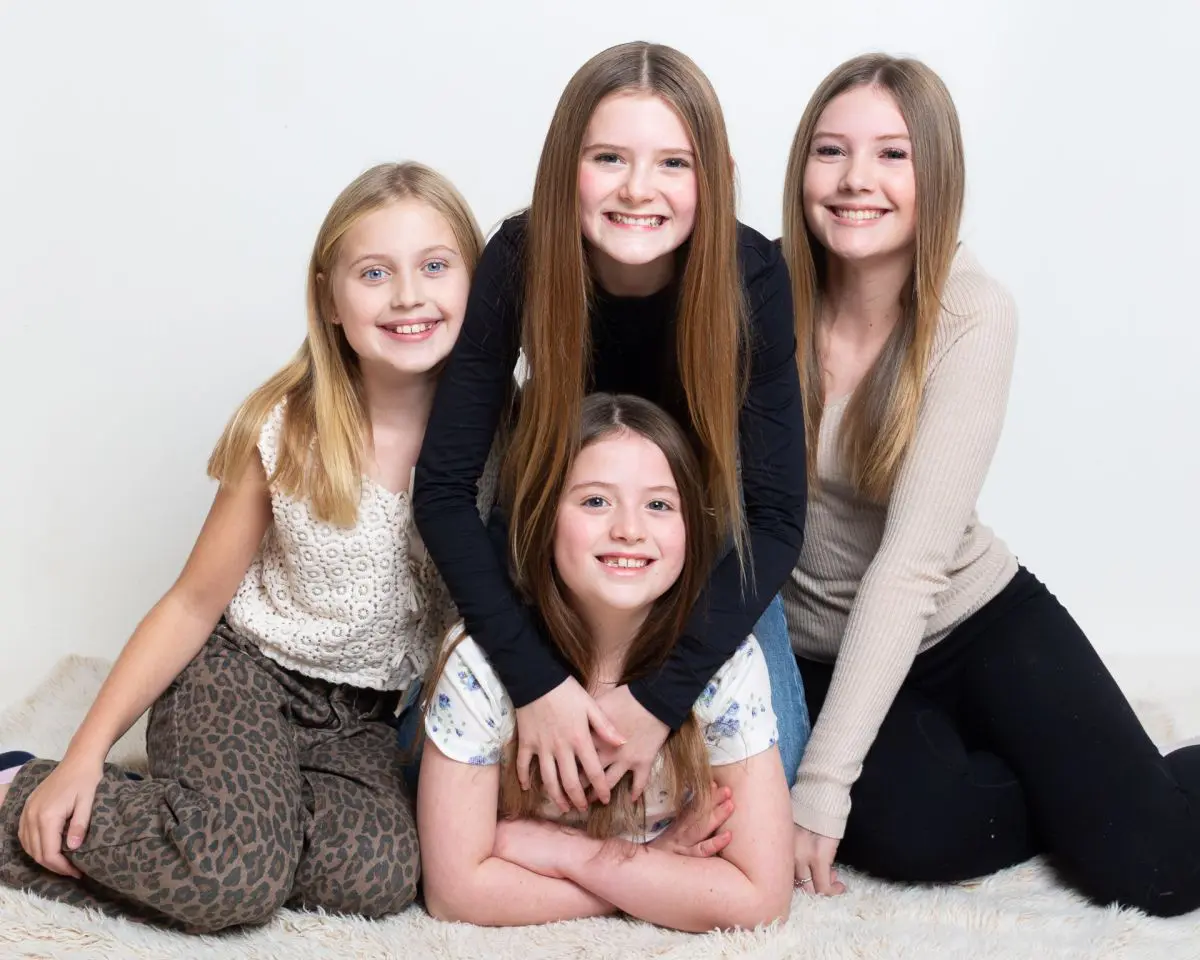 A group of four girls pose for a family photograph