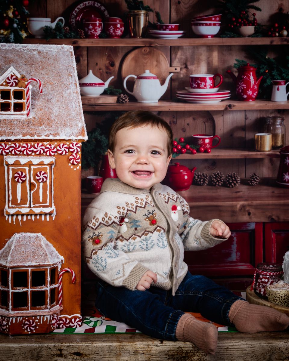 Christmas Photo Shoots West Sussex 2025 A baby sits beside a giant gingerbread house
