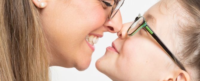 a mother and daughter pose nose to nose for a fun portrait shot