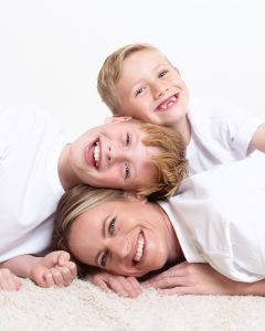 Family Portrait Photo Shoot East Grinstead West Sussex a mum and her two sons pose with their heads all lined up for a family photo shoot