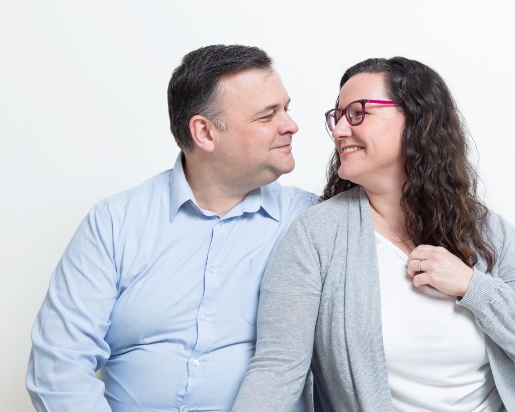 a couple look at each other in a portrait shoot