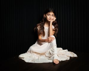 a girl poses seated in a long dress
