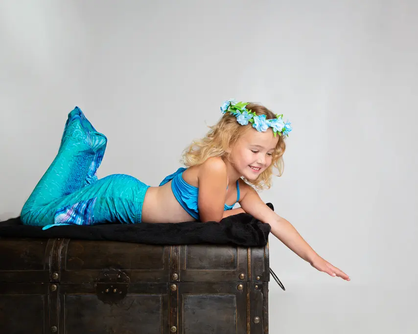 a little girl posing at a mermaid photo shoot