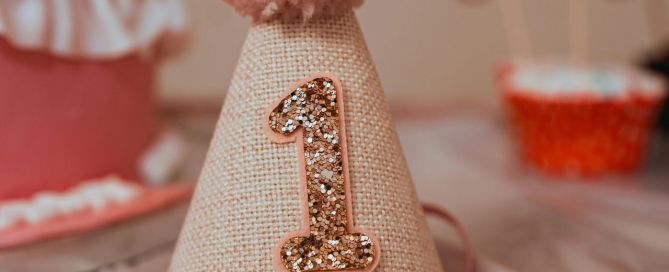 a pink first birthday party hat