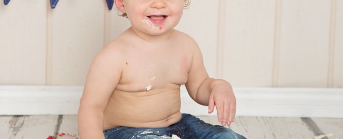 a little boy with a cake topped with fruit