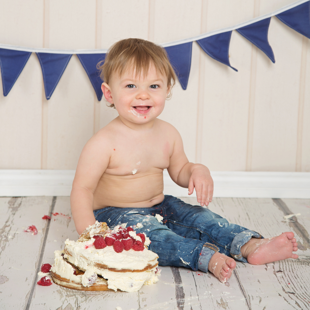 a little boy with a cake topped with fruit