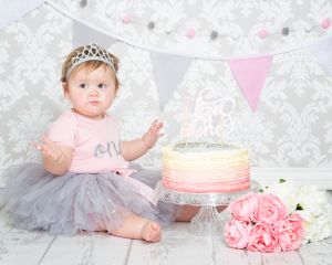 a little girl wearing a tiara at her cake smash photo shoot