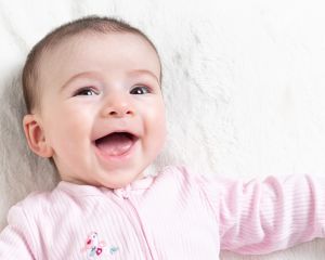 a little girl looks at the camera and smiles for her first photo shoot