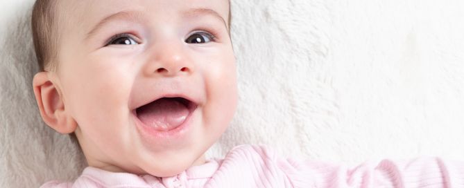a little girl looks at the camera and smiles for her first photo shoot