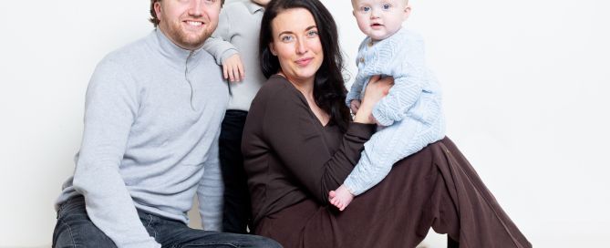 A family of four pose for a photo shoot with their newest family member
