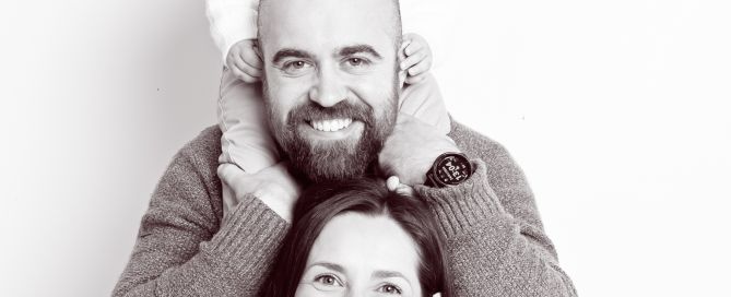 a family pose in a black and white image in a professional portrait studio