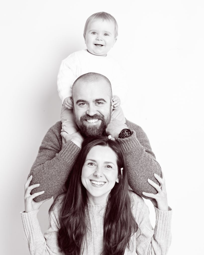 a family pose in a black and white image in a professional portrait studio