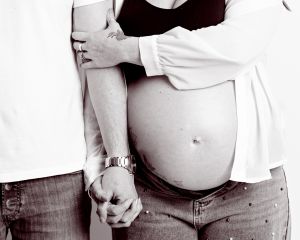 maternity portrait image in black and white of a couple holding hands