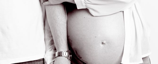 maternity portrait image in black and white of a couple holding hands