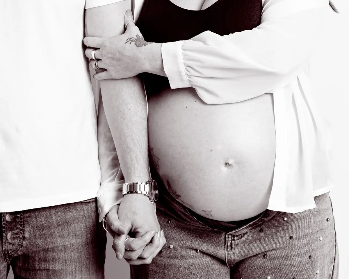 maternity portrait image in black and white of a couple holding hands