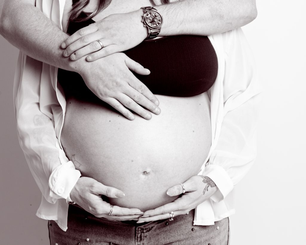 maternity portrait image in black and white of a couple standing together