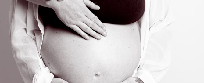 maternity portrait image in black and white of a couple standing together