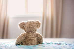Teddy bear sitting on a bed