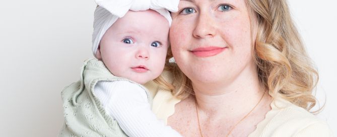 a mum and daughter pose for a photo together in a portrait studio