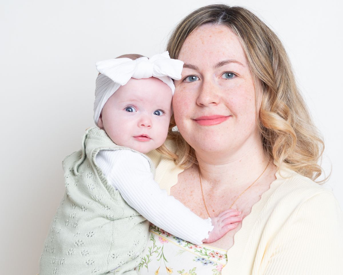a mum and daughter pose for a photo together in a portrait studio
