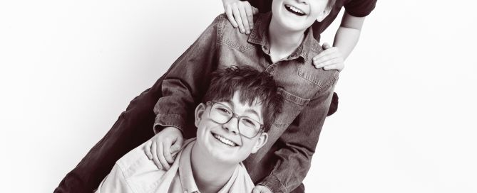 a black and white image of three brothers forming a stack in a portrait studio