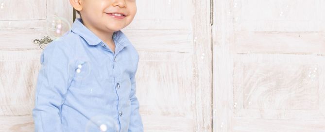 a little boy plays in the bubbles at a photo shoot