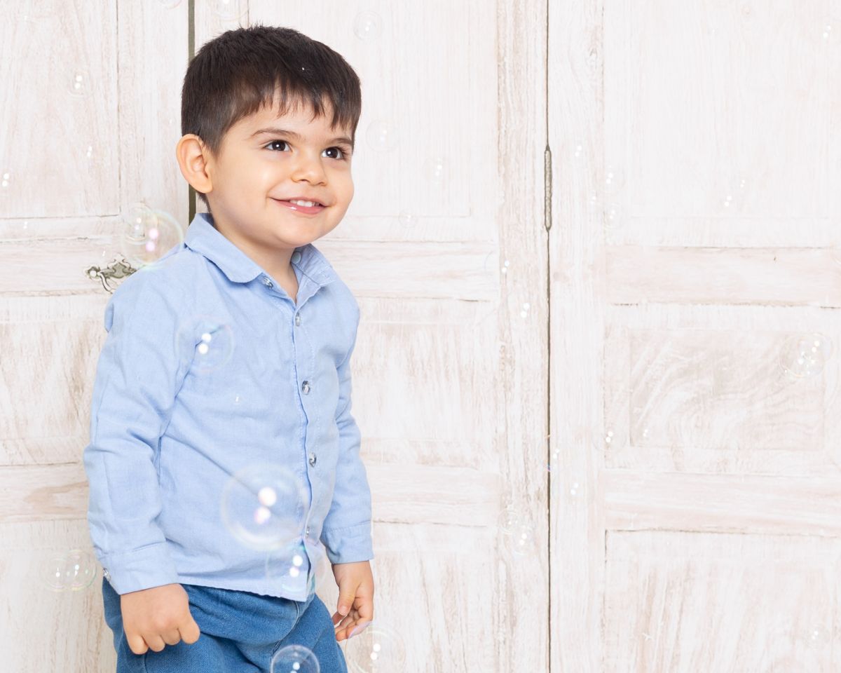 a little boy plays in the bubbles at a photo shoot