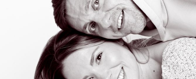 a mum, dad and baby make a stack of their heads at a portrait photo shoot