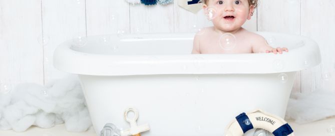 a little boy in a miniature bath tub surrounded by bubbles