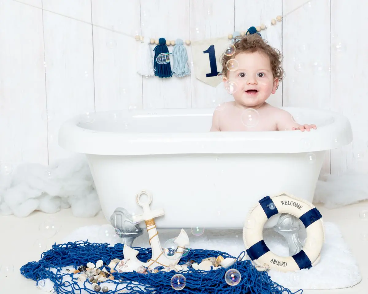 a little boy in a miniature bath tub surrounded by bubbles