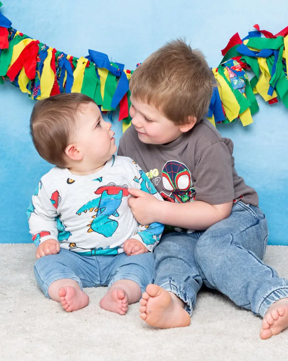 two brothers look at each other in a photo shoot