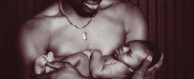 a newborn sharing a skin to skin moment with dad at a photo shoot
