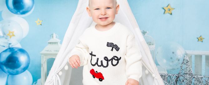 a little boy celebrating his second birthday in a two jumper at a photo shoot