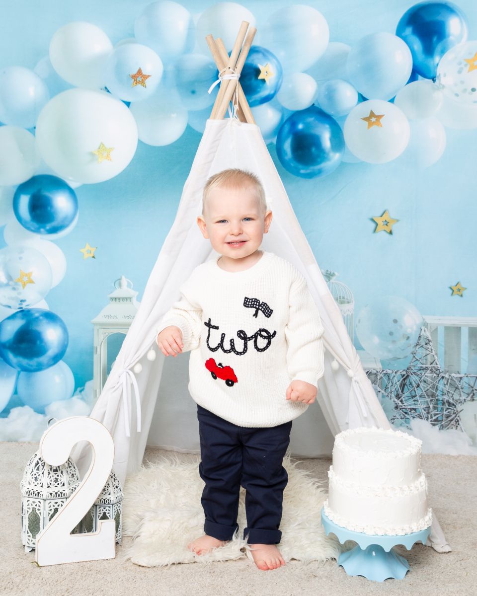 a little boy celebrating his second birthday in a two jumper at a photo shoot