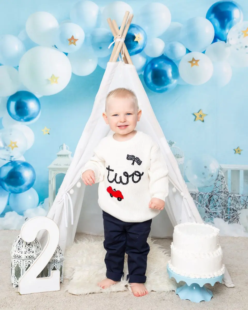 a little boy celebrating his second birthday in a two jumper at a photo shoot