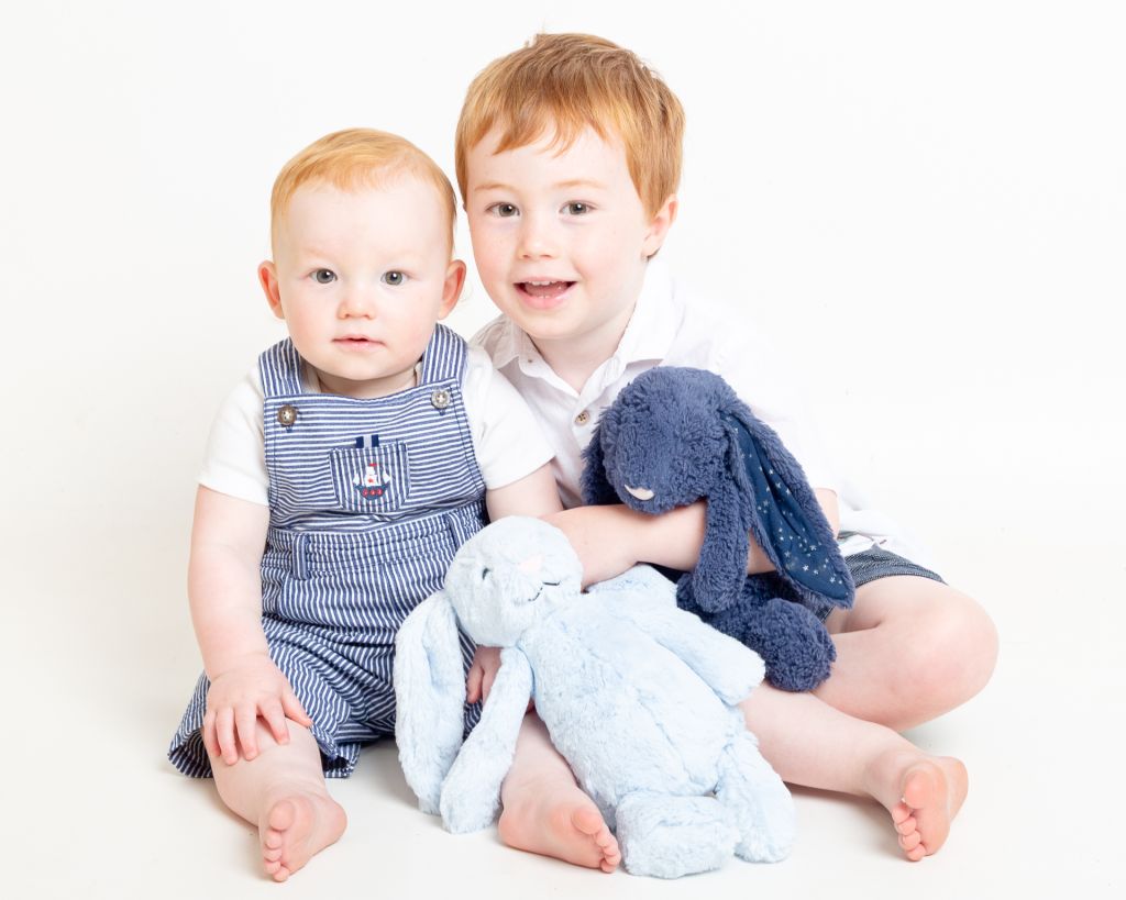 two boys pose with bunnies at a photo shoot