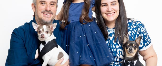 a family pose together for a portrait, mum, dad, daughter and two chihuahuas
