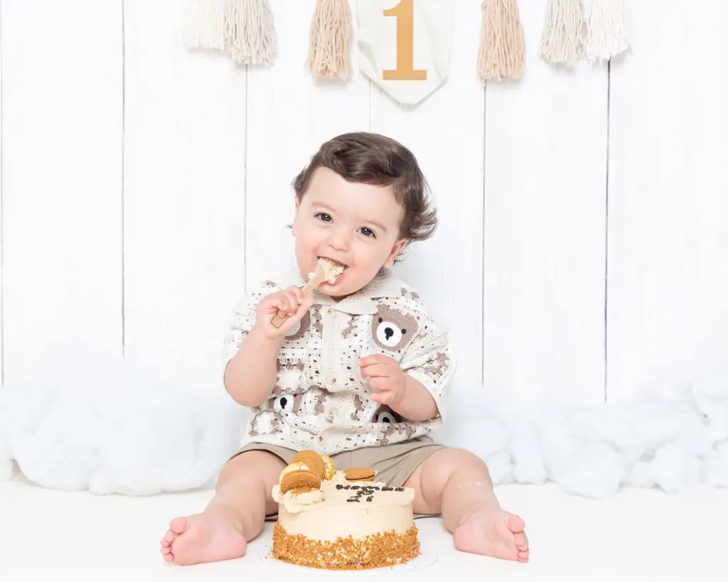 a little boy enjoying a birthday cake in a matching outfit