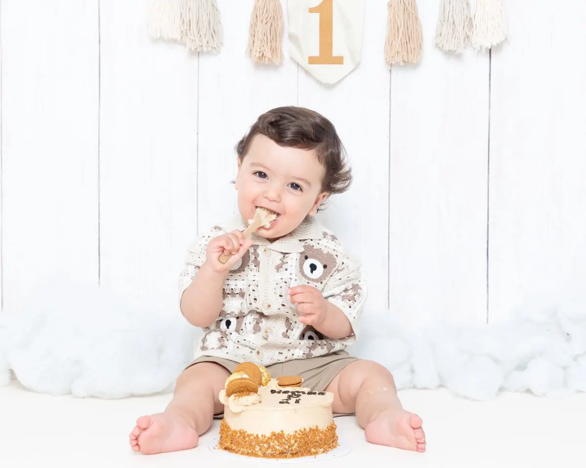 a little boy enjoying a birthday cake in a matching outfit
