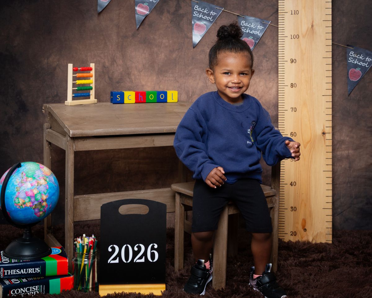 a little girl in a navy school jumper at photo shoot