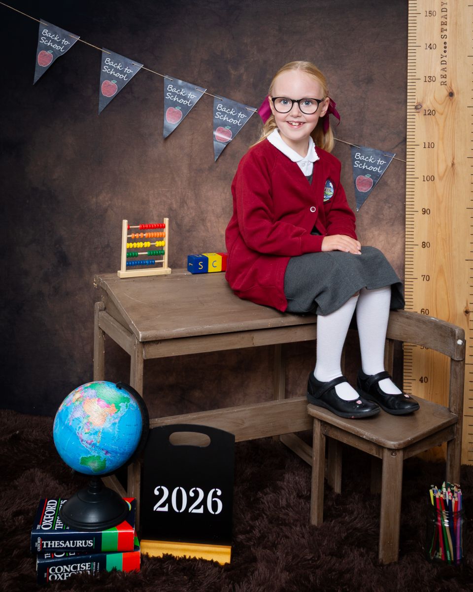 a little girl in a burgundy cardigan at photo shoot